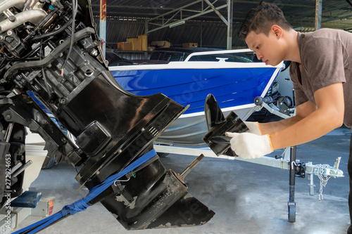 Repairing engines on aluminum boats , The technician is removing the boat parts to make the paint