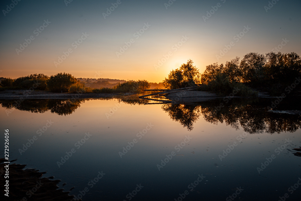 beautiful sunset on the river bank in the summer evening