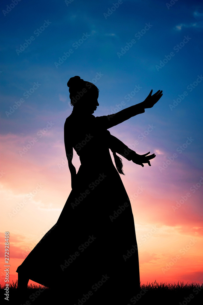 woman dancing the Bollywood Indian dance at sunset