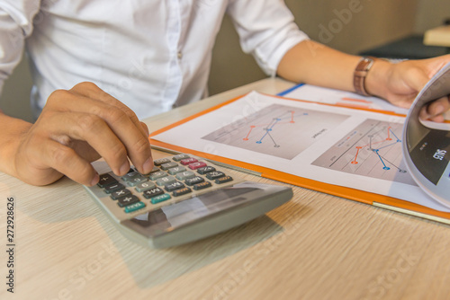 Businessman using calculator and analyzing financial number on document