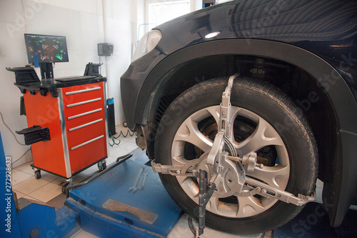 car repair: wheel replacement closeup. mechanic screwing or unscrewing car wheel at car service garage