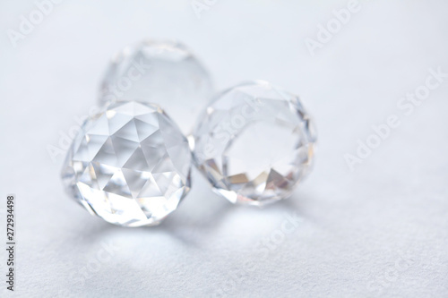 Abstract diamond stones on white background. Beautiful crystal transparent gems, geometric polygon shapes. Macro view, shallow depth of field
