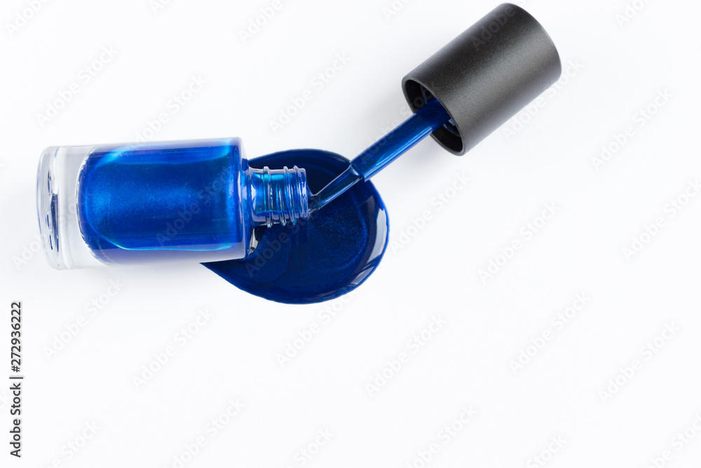 Spilled blue nail polish on a white background, manicure concept. Copyspace for text Spilled blue nail polish on a white background, manicure concept. Copyspace for text