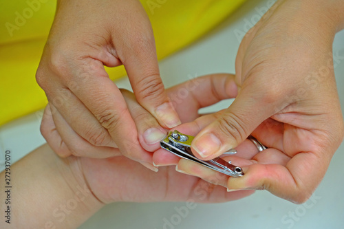 Mother doing nail cutting for a child. Mother s love.