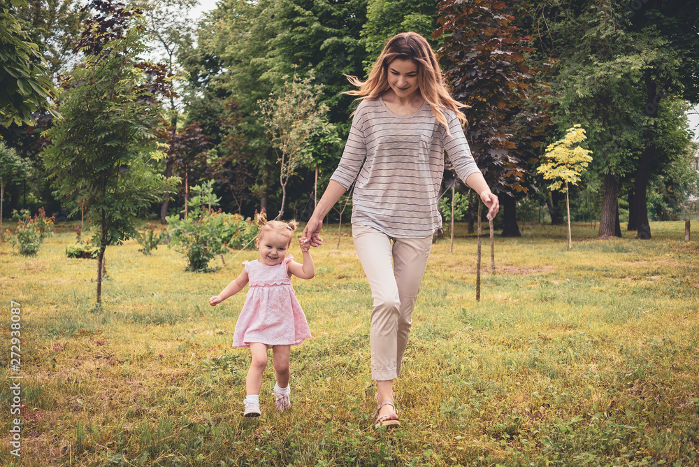 Fototapeta premium Happy young mother with baby daughter in a park