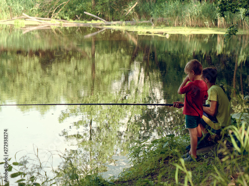 teen child catches a fishing rod on the pond.