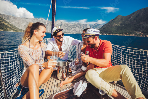 Smiling friends with glasses of champagne on yacht. Vacation, travel, sea, friendship and people concept © Mediteraneo