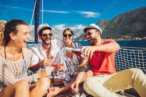Smiling friends with glasses of champagne on yacht. Vacation, travel, sea, friendship and people concept © Mediteraneo