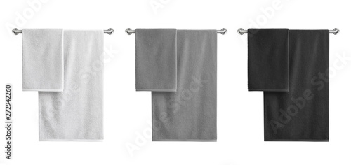 Photo White, black and grey cotton terry towels hanging on a rail isolated