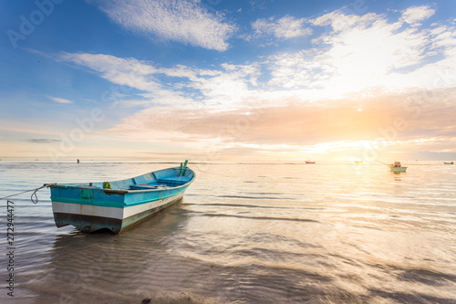 boat by the beachside during beautiful sunrise