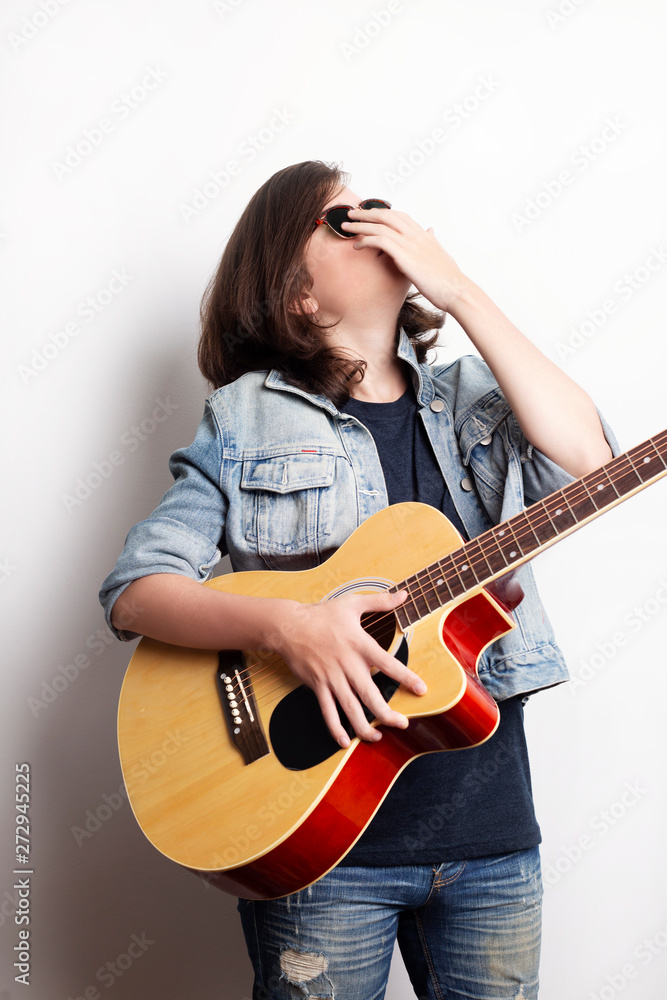 Portrait of a teenager with guitar in studio. Portrait of a teenager with guitar in studio.
