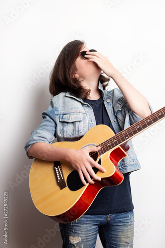 Portrait of a teenager with guitar in studio.