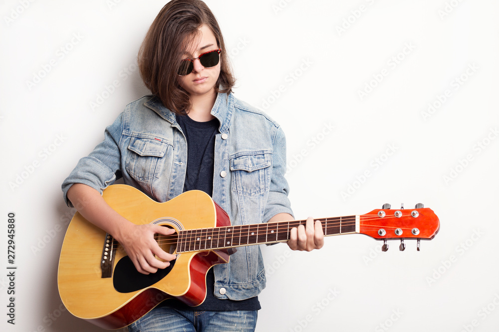Portrait of a teenager with guitar in studio. Portrait of a teenager with guitar in studio.
