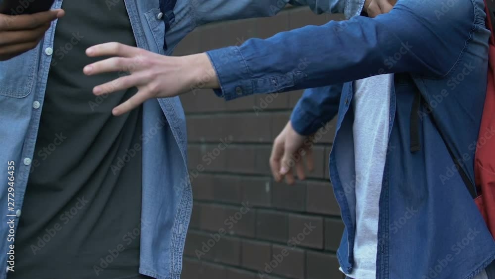 Rude black teenager grabbing caucasian boys smartphone trying to show disrespect Rude black teenager grabbing caucasian boys smartphone trying to show disrespect