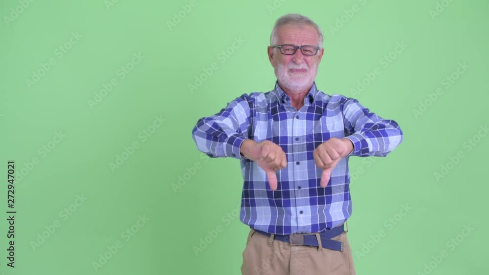 Stressed senior bearded hipster man snapping fingers and giving thumbs down Stressed senior bearded hipster man snapping fingers and giving thumbs down