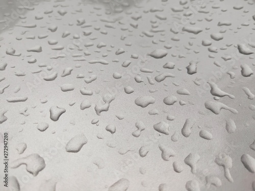 Rain water on a silver car skirt 