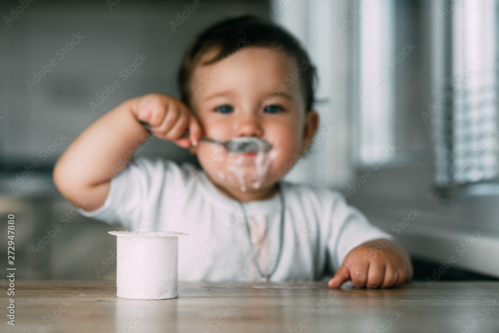 A little charming girl eats yogurt all smeared herself A little charming girl eats yogurt all smeared herself