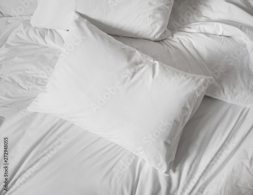 White pillows, duvet and duvetcase in a bed. Top view.