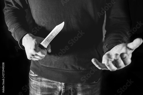 Man holding in hands and demanding money. Robber in black sweater. Dangerous people.