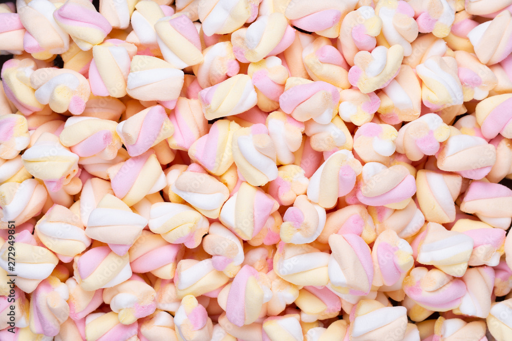 Marshmallows on blue background with copyspace. Flat lay or top view. Background or texture of colorful mini marshmallows. Marshmallows on blue background with copyspace. Flat lay or top view. Background or texture of colorful mini marshmallows.