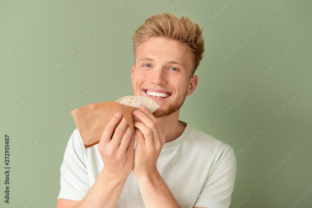 Man eating tasty taco on color background Man eating tasty taco on color background
