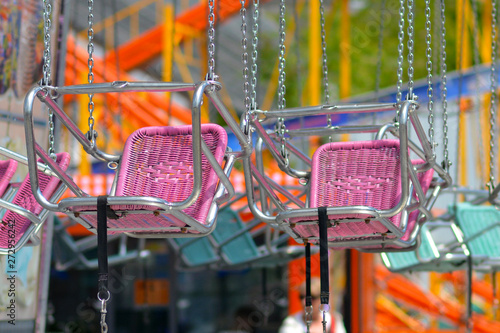 Empty pink chair of chair swing ride at amusement park