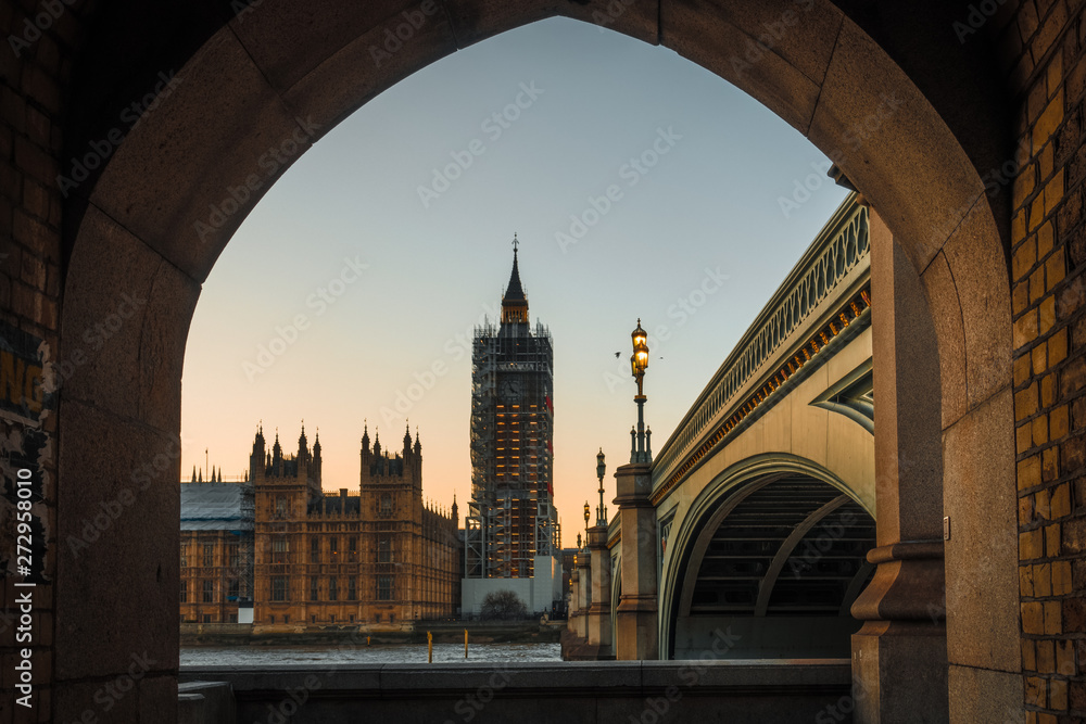 Big ben framed by a stone wall
