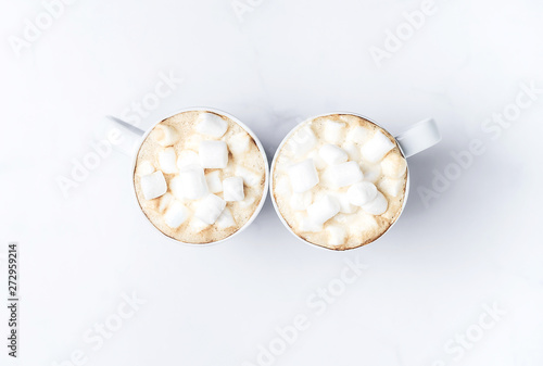 Romantic cozy desk top with two cups of coffee with marshmallows on marble table. Top view. Space for text .