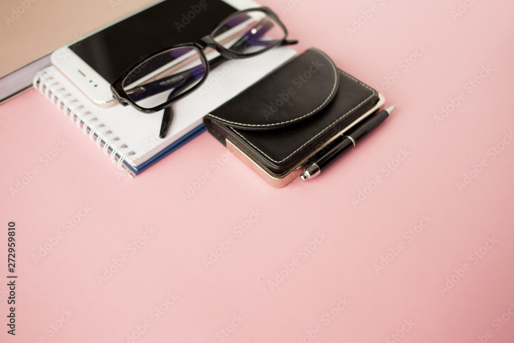 Stationery, white smartphone, glasses, pen, wallet, watch, calendar, notebook. Pink background. Stationery, white smartphone, glasses, pen, wallet, watch, calendar, notebook. Pink background.
