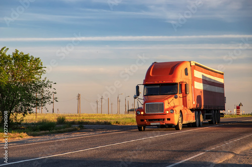 Canvas Print A large red truck transports goods on a long-distance road