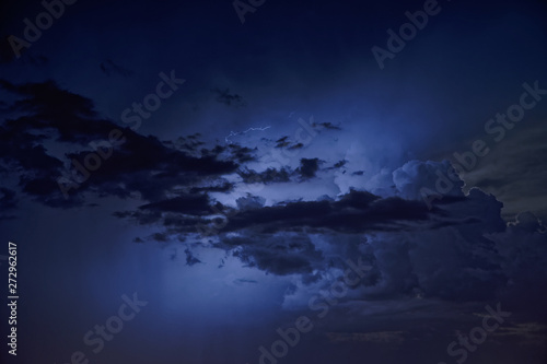 Flashes of lightning in the night cloudy sky. Thunderstorm.