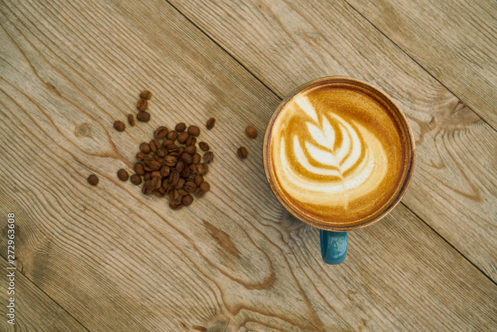 Latte coffee and coffee beans on the wooden table Latte coffee and coffee beans on the wooden table