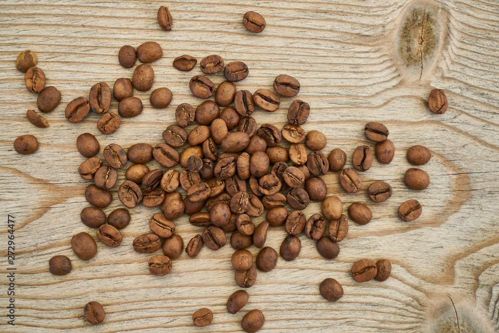 Roasted coffee beans on the wooden table Roasted coffee beans on the wooden table