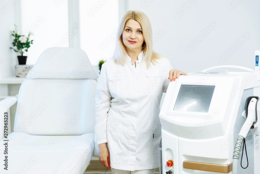 A woman tunes a laser hair removal machine A woman tunes a laser hair removal machine