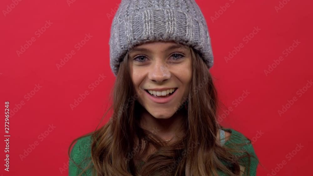model in a hat on a red background throws up confetti model in a hat on a red background throws up confetti