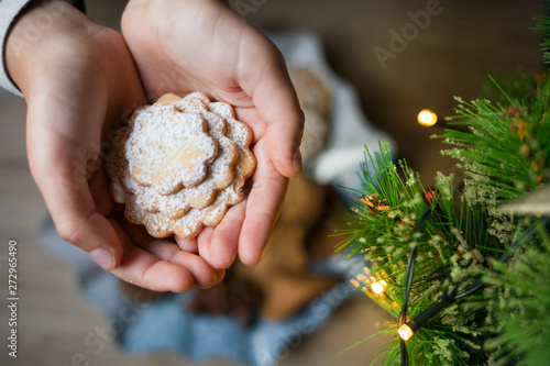 Christmas biscuits in the shape of heart in children's palms.