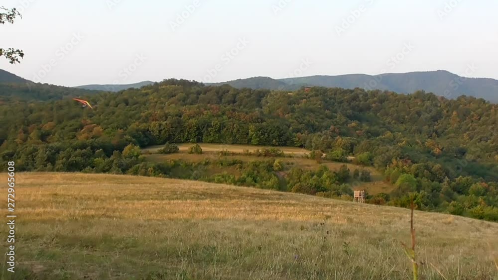 Hang Glider Banking Above A Hillside. Hang Glider Banking Above A Hillside.