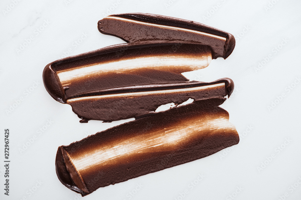 Top view of dark chocolate brushstrokes on white background