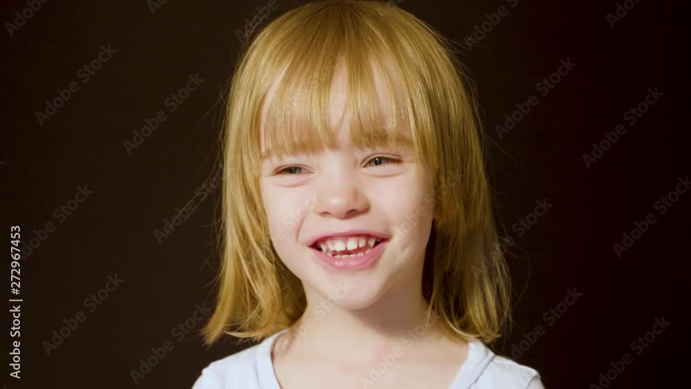 Portrait of a beautiful little girl turning toward the camera and smiling Portrait of a beautiful little girl turning toward the camera and smiling