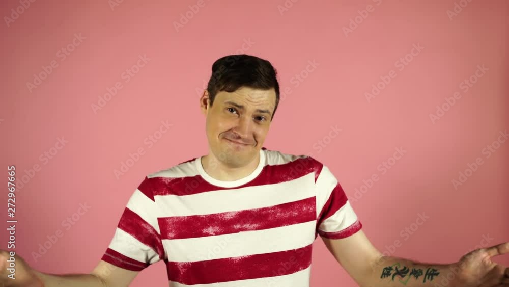 A man in a striped t-shirt on a pink background. Looking camera says yes A man in a striped t-shirt on a pink background. Looking camera says yes