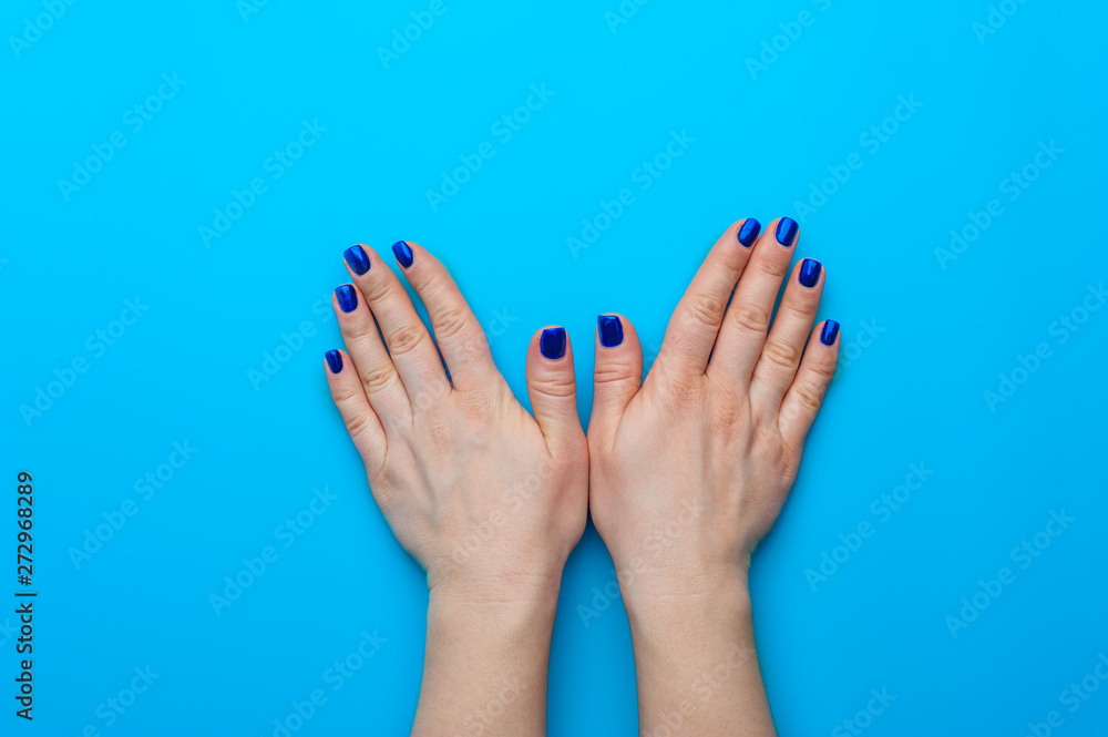 Female hand with dark blue nails showing gesture Female hand with dark blue nails showing gesture