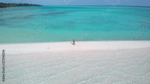 Drone shot around a tourist couple walking on Mansalangan Sandbar in Balabac, Palawan, Philippines photo