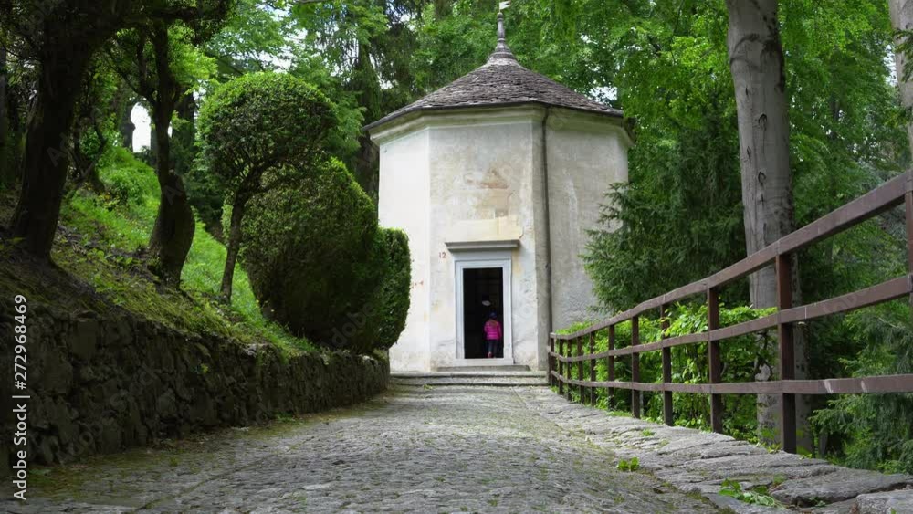 A mother and her little daughter carrying a teddy bear visiting the sacred mountain of Varallo christian devotional complex, a unesco world heritage site near the town of Varallo Sesia in Italy A mother and her little daughter carrying a teddy bear visiting the sacred mountain of Varallo christian devotional complex, a unesco world heritage site near the town of Varallo Sesia in Italy
