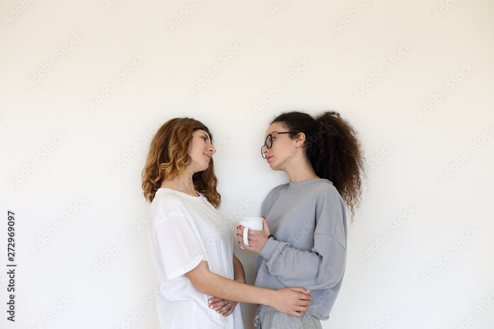 Lesbian couple relationship. Two casual millennial women looking to each other with love and affection. Lesbian couple relationship. Two casual millennial women looking to each other with love and affection.