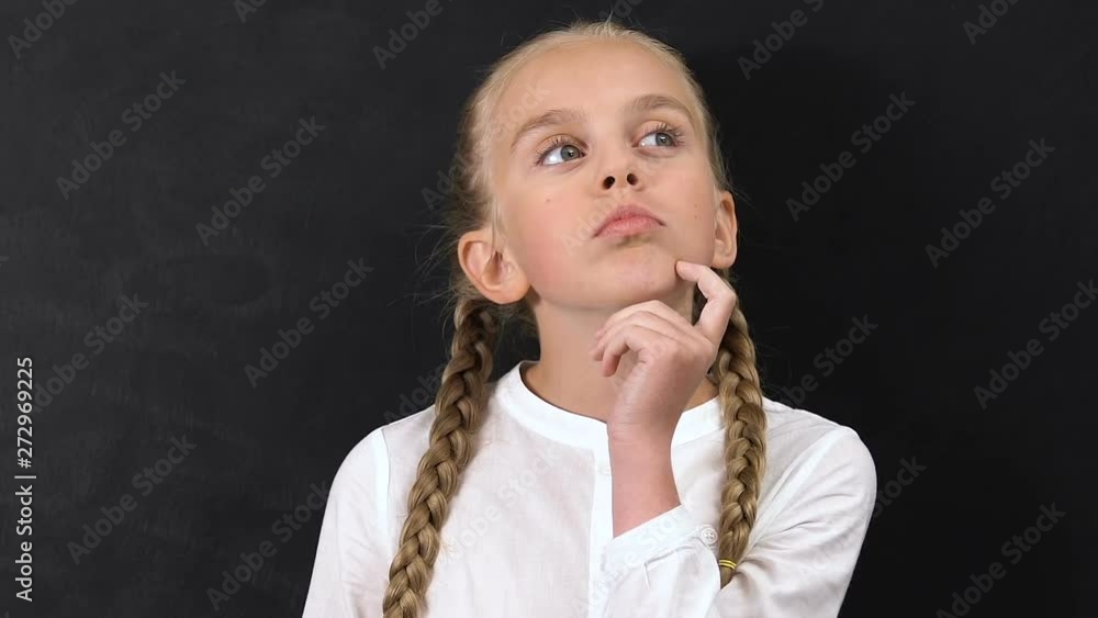 Pensive little girl against blackboard, creativity and inspiration concept Pensive little girl against blackboard, creativity and inspiration concept