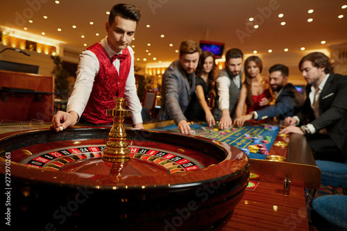 The croupier holds a roulette ball in a casino in his hand. Fototapeta