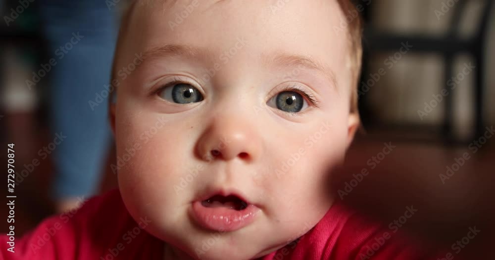 Cute little baby smiles and grabs the camera, close up shot in slow motion Cute little baby smiles and grabs the camera, close up shot in slow motion
