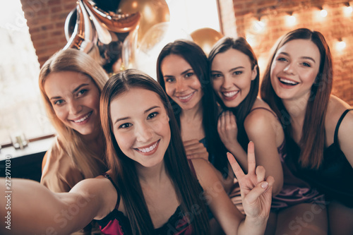 Close up photo five beautiful she her chic ladies make take selfies show v-sign having fun joy amazed sit bed linen sheets best buddies wear sleep costumes girls night theme party house room indoors