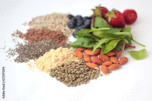 Obraz na płótnie Sample foods from low-GI PCOS (Polycystic Ovary Syndrome) diet. Lentils, almonds, chia seeds, sunflower seeds, flaxseed, maca powder, blueberries, strawberries and dark leafy greens. w salonie