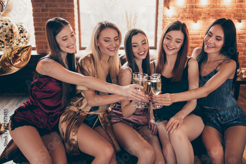 Close up photo fellows five funny beautiful event she her hang out ladies hands arms raise glasses festive golden beverage short nightie sit sheets clink tell talk toasts sleep costumes room indoors
